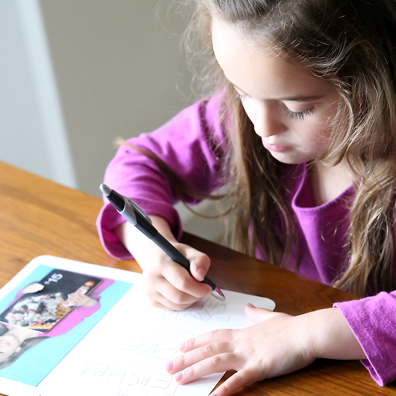 Girl writing a teacher appreciation card