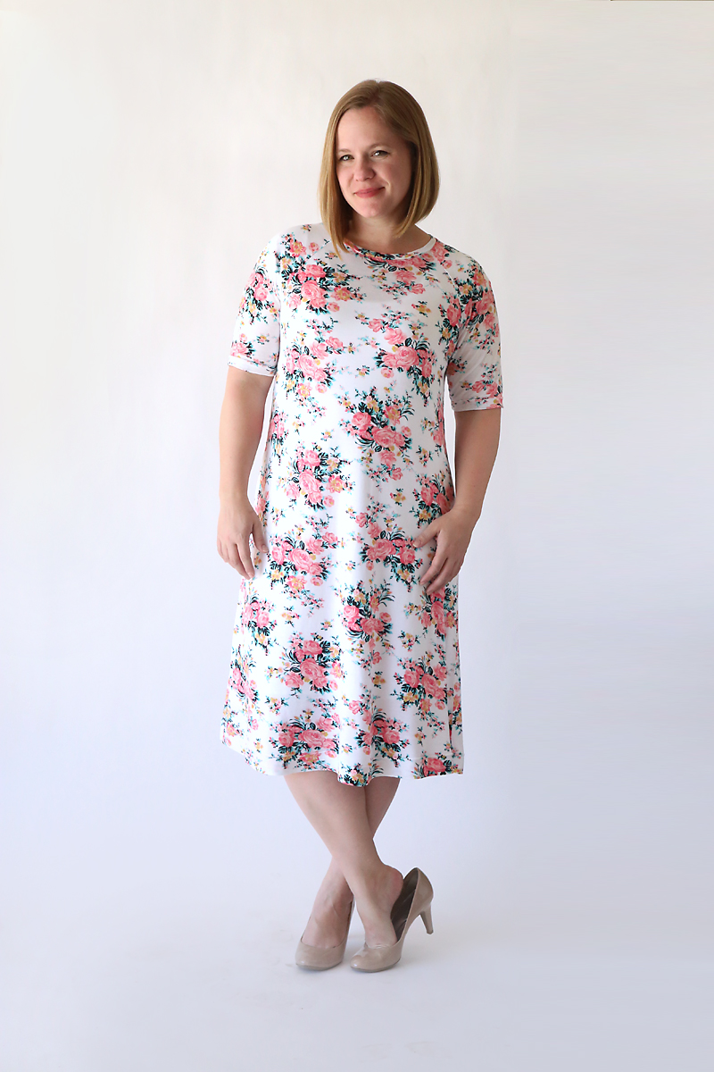 a woman wearing a floral swing dress made from a sewing tutorial