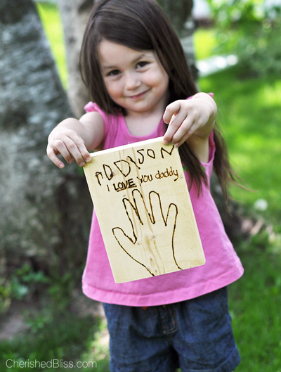 Girl holding a wood burned Father\'s Day card