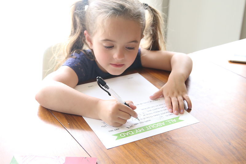 A little girl filling in a father\'s day questionnaire