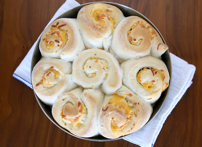 Eight rolls filled with cheese and garlic in a round pan
