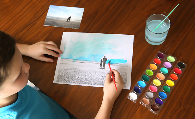 Boy painting on a coloring page made from a photo