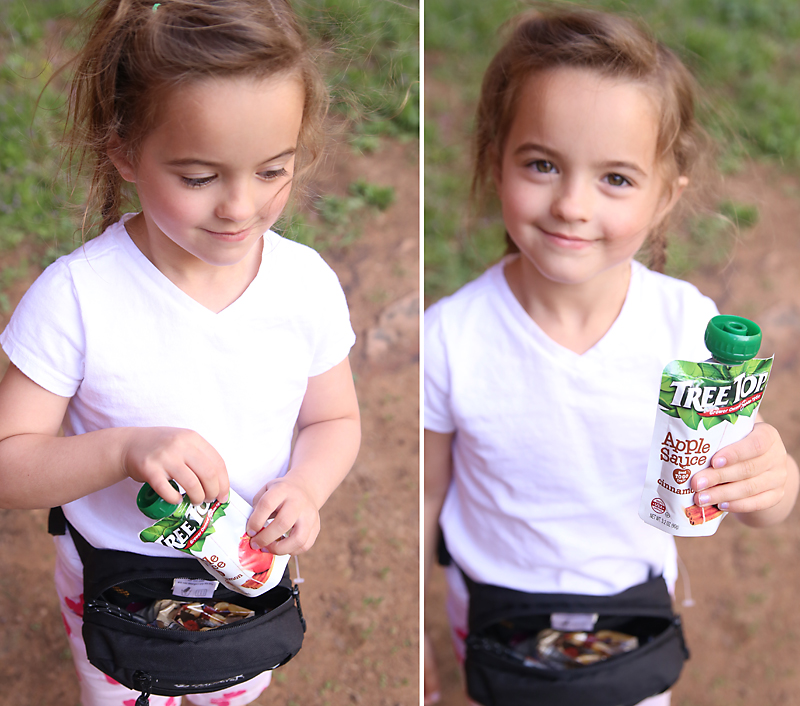 A little girl holding an applesauce pouch