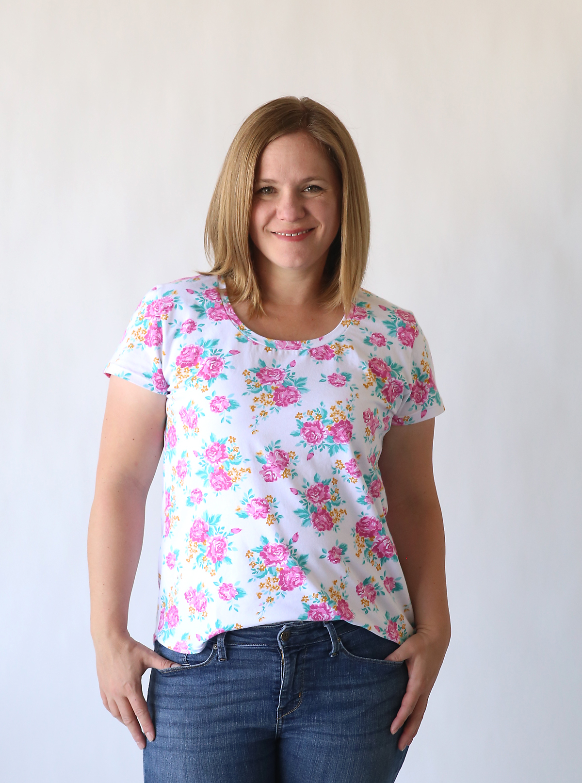 A woman wearing a floral t-shirt made from a free pdf sewing pattern