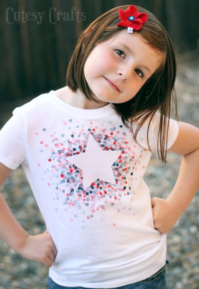 A girl wearing a t-shirt decorated with a white star and blue and red dots