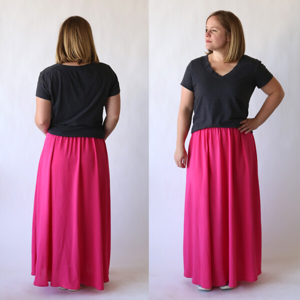 A woman wearing a long pink maxi skirt and dark grey t-shirt