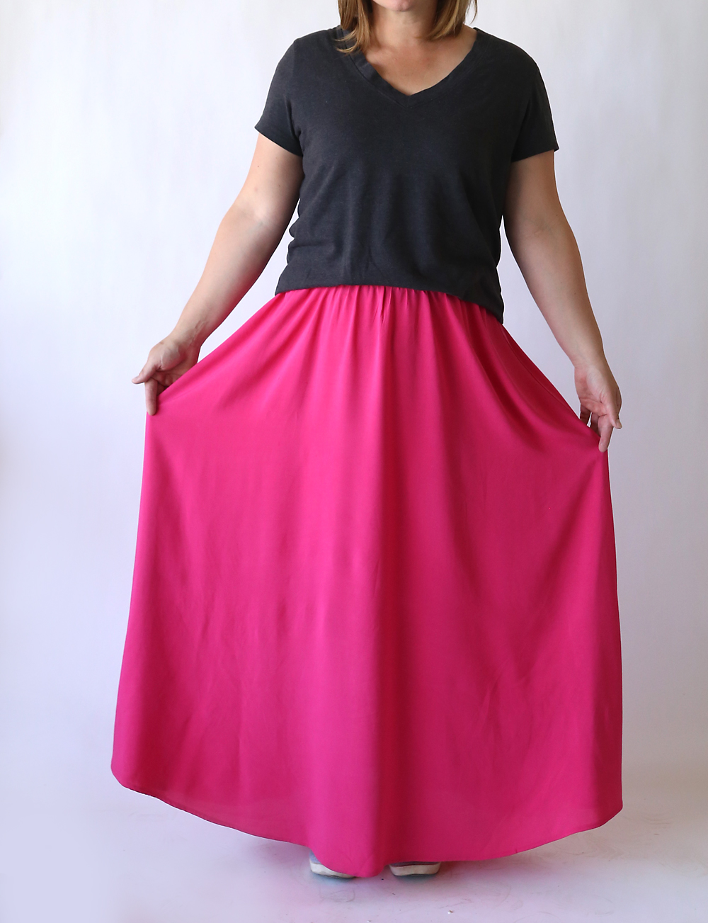 A woman wearing a long pink maxi skirt made from woven fabric