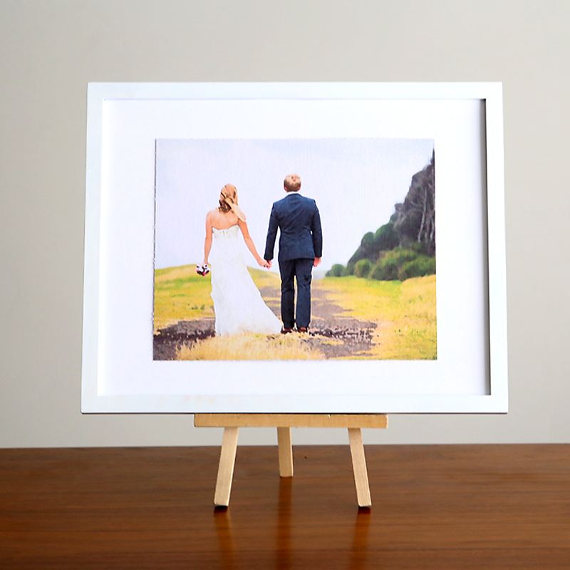A framed painting of a bride and groom