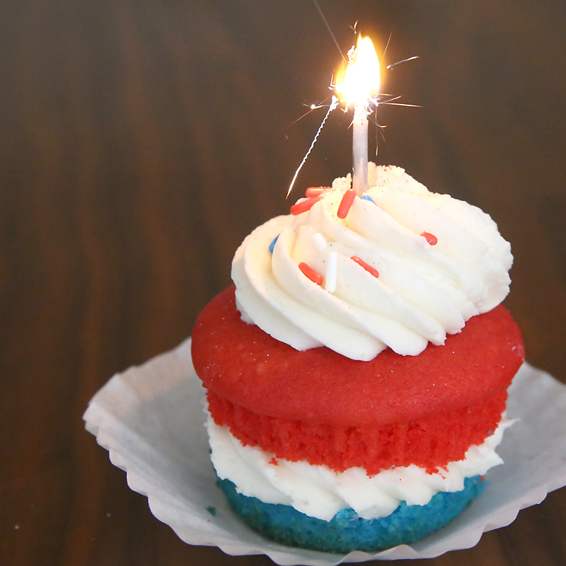 Red white and blue cupcake with sparkler candle in it