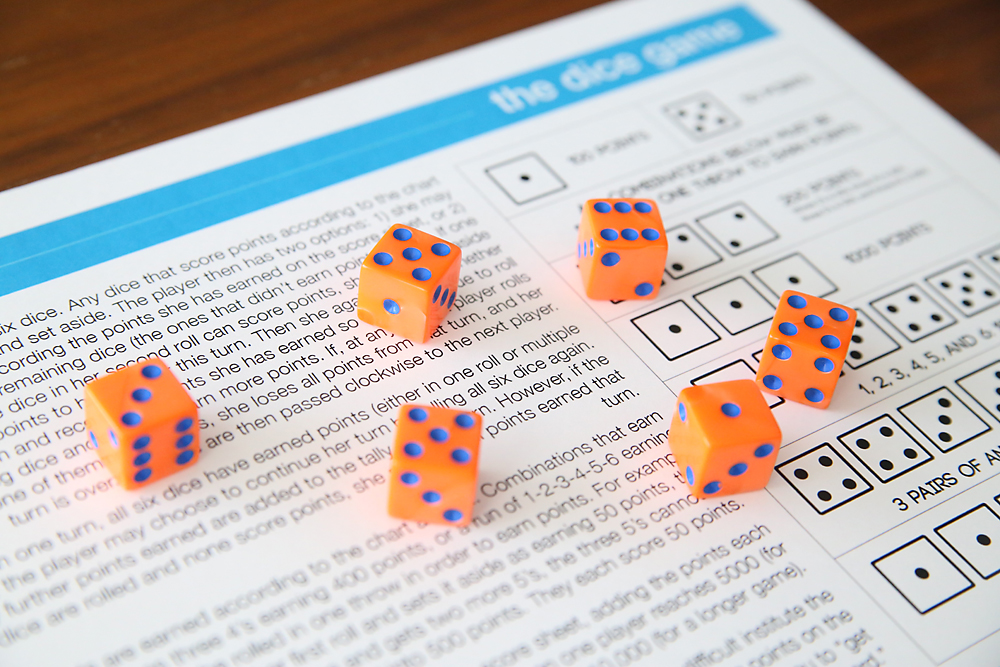 Six dice sitting on the instructions for the dice game