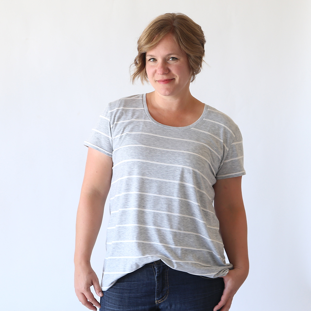 A woman wearing a grey and white striped relaxed fit t-shirt