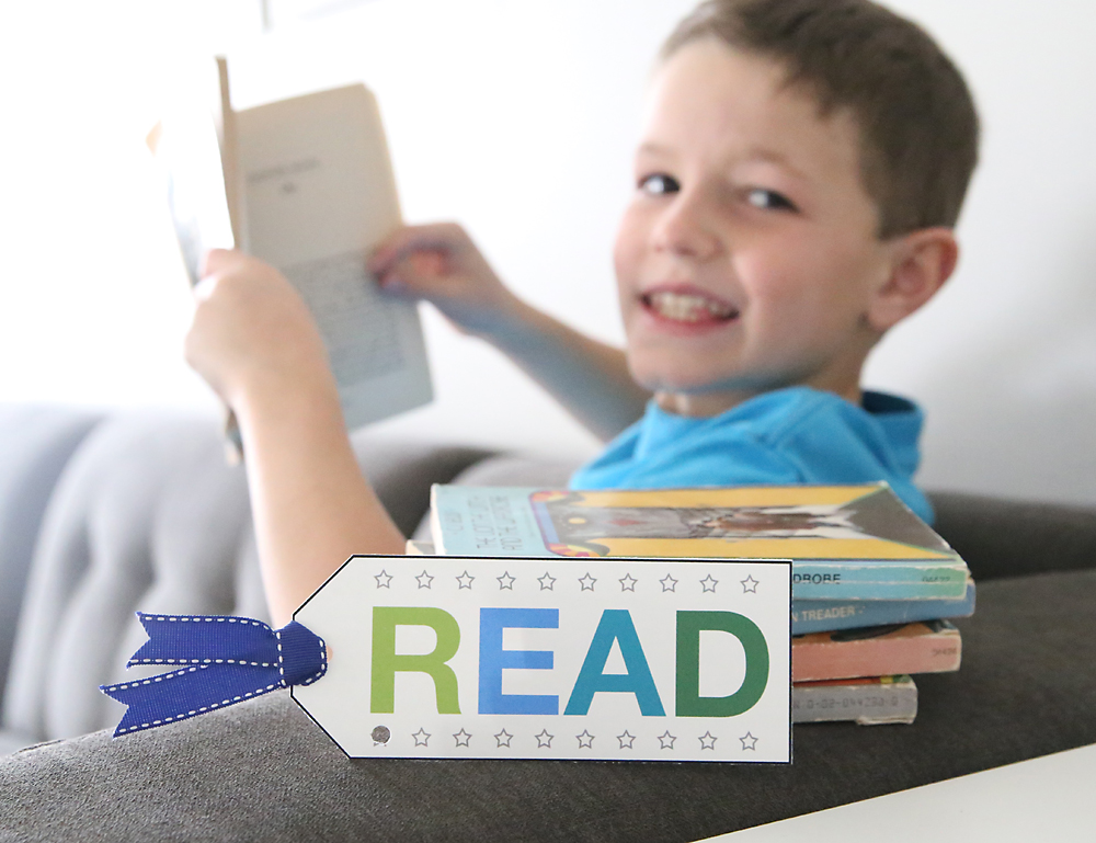 Boy reading a book with a punch card bookmark