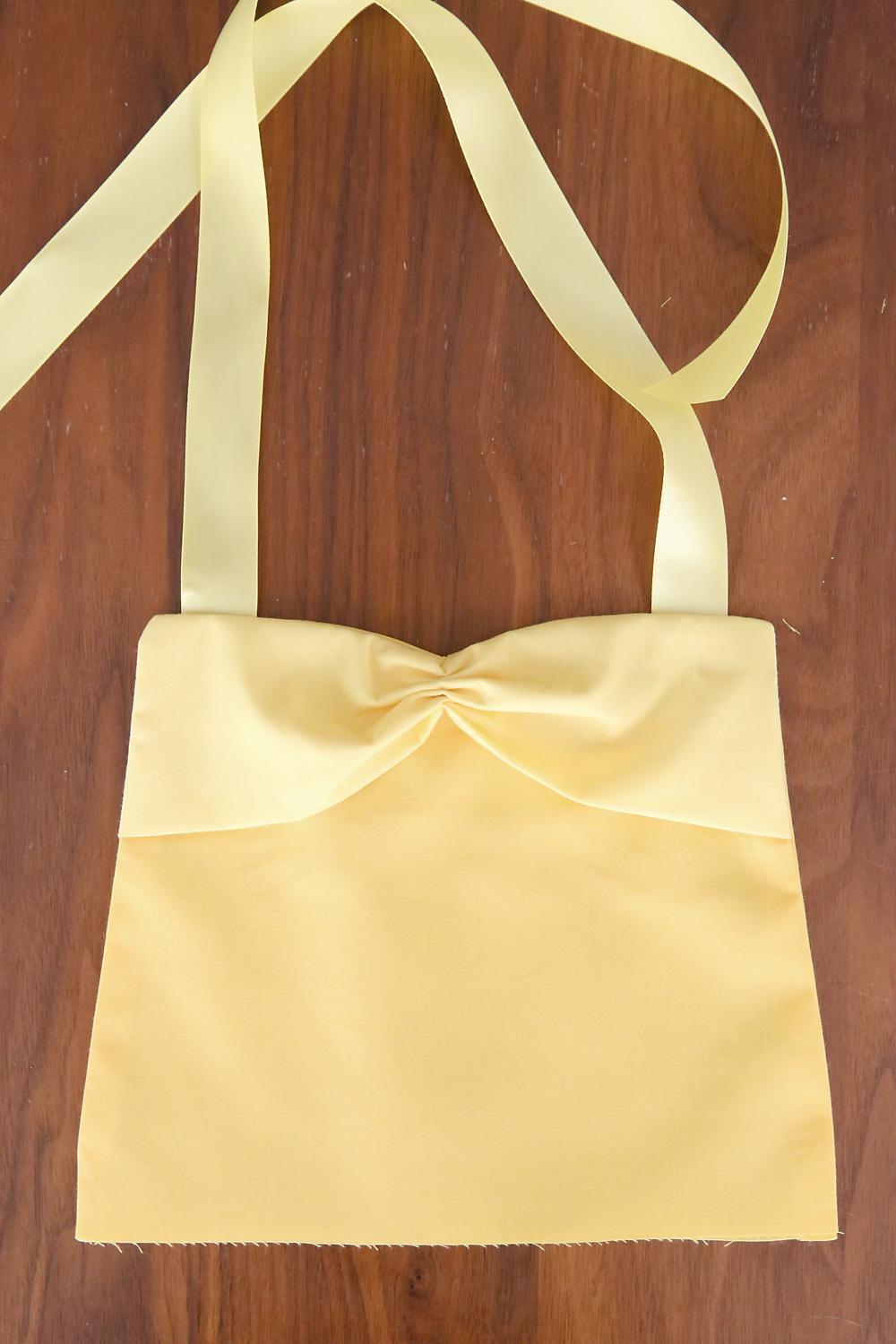 Top of apron sewn together with shoulder strap ribbons attached