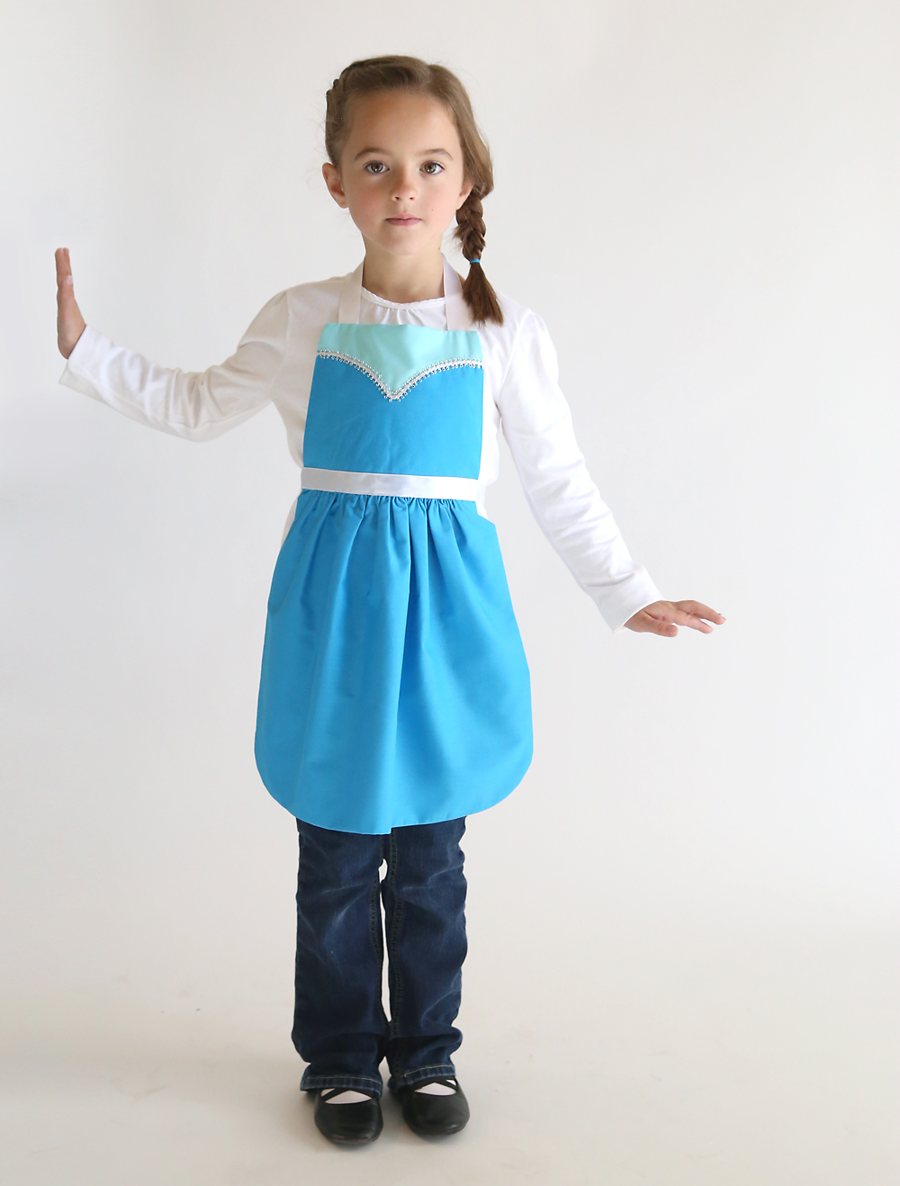 A young girl wearing a Elsa princess dress up apron made from a free pdf sewing pattern