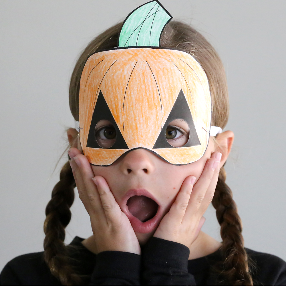 Girl wearing paper pumpkin Halloween mask