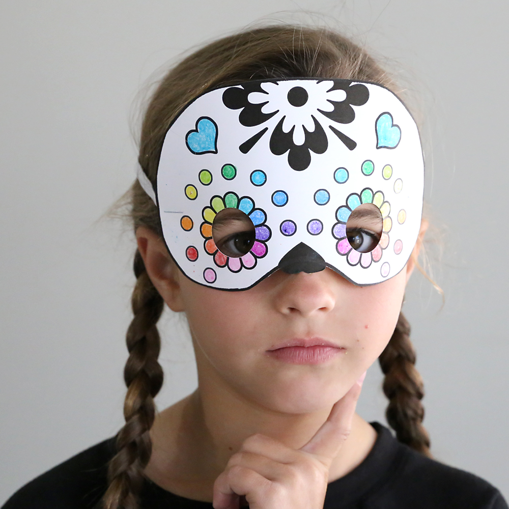 Girl wearing paper sugar skull Halloween mask