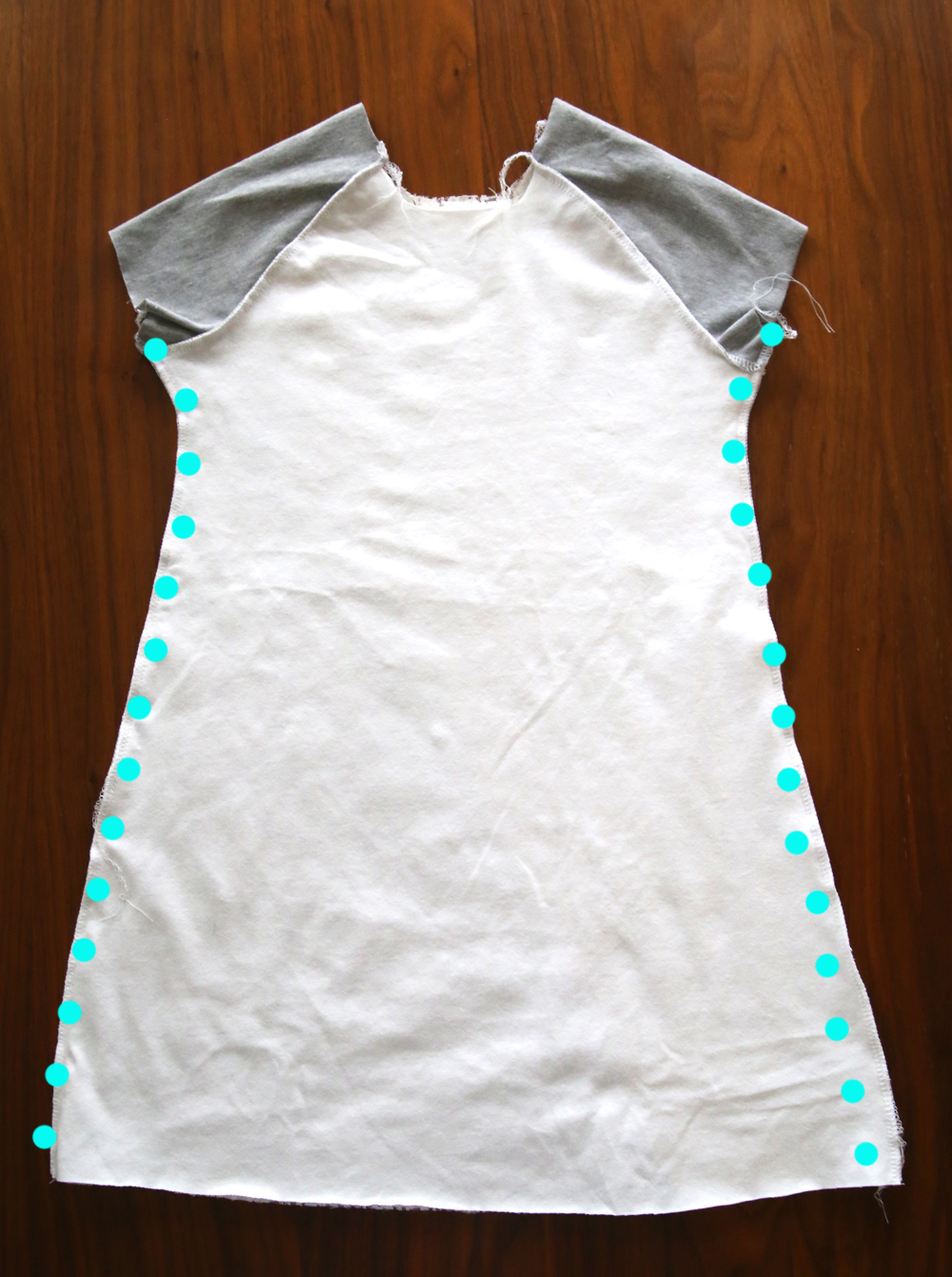 Raglan play dress inside out with side seams marked