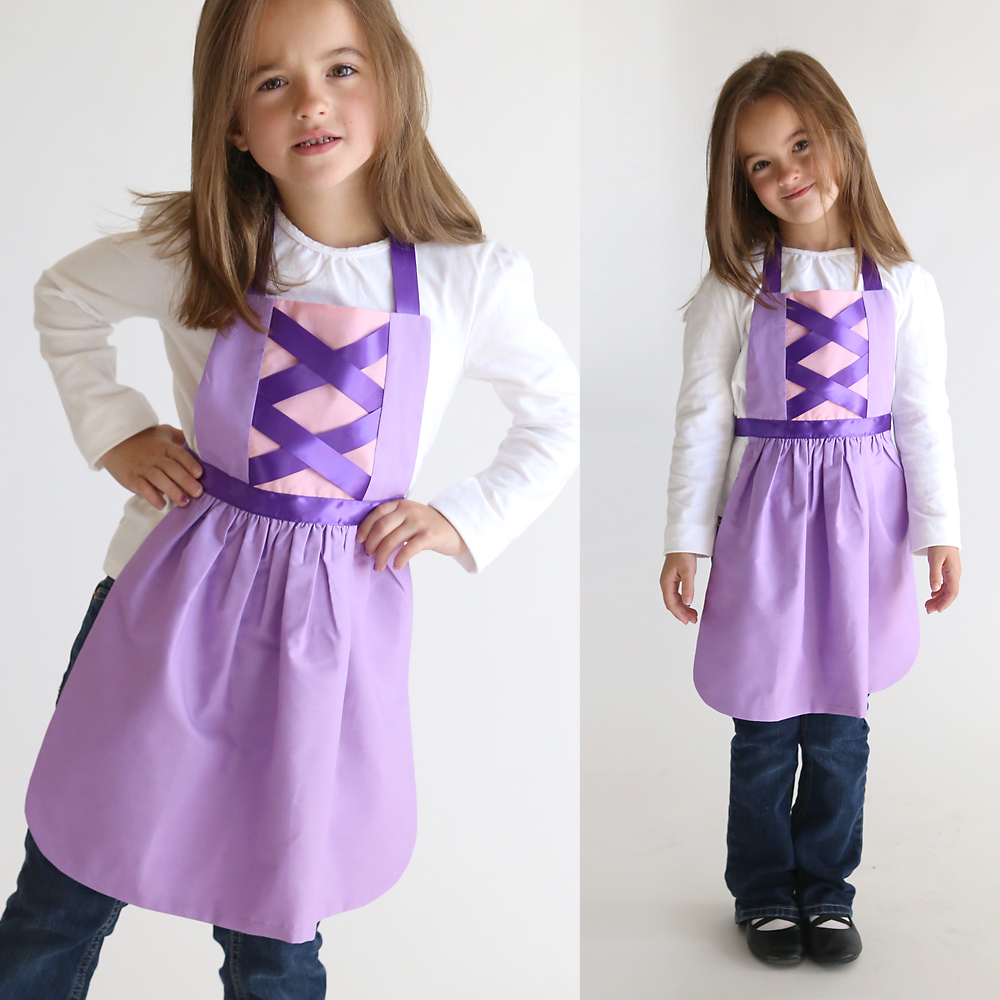 A girl wearing a pink and purple Rapunzel princess dress up apron made from a free pdf sewing pattern