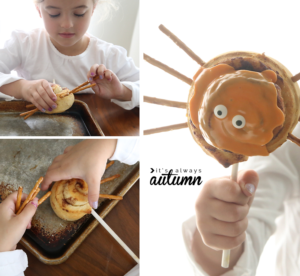 A little girl holding a spider cinnamon roll she has made