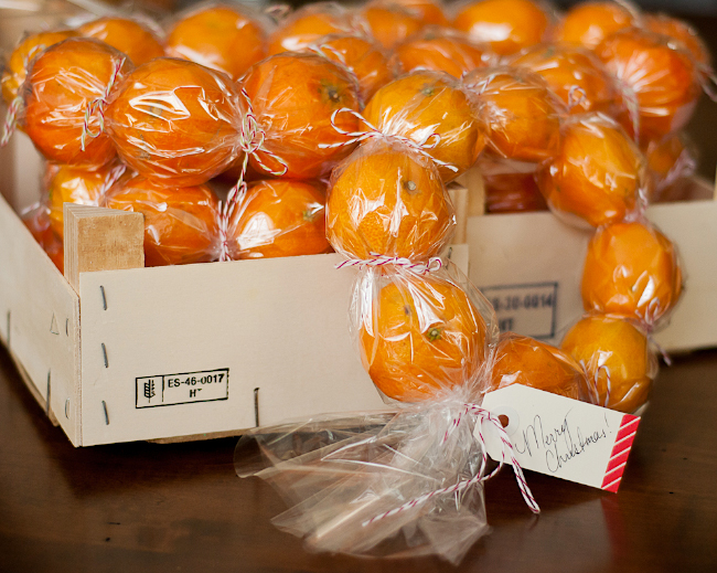 Small oranges in cellophane tied into a wreath shape to make a gift