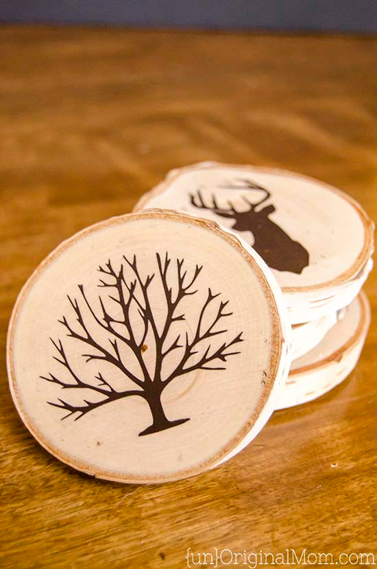 DIY coasters made from wood slices decorated with tree shape and antler shape