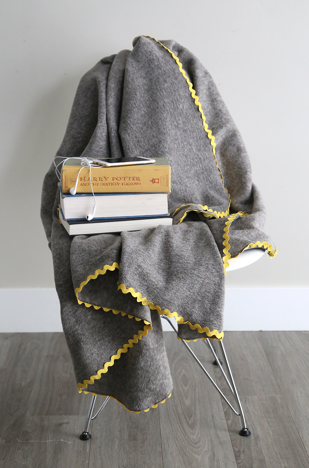 DIY Fleece blanket draped over a chair with books