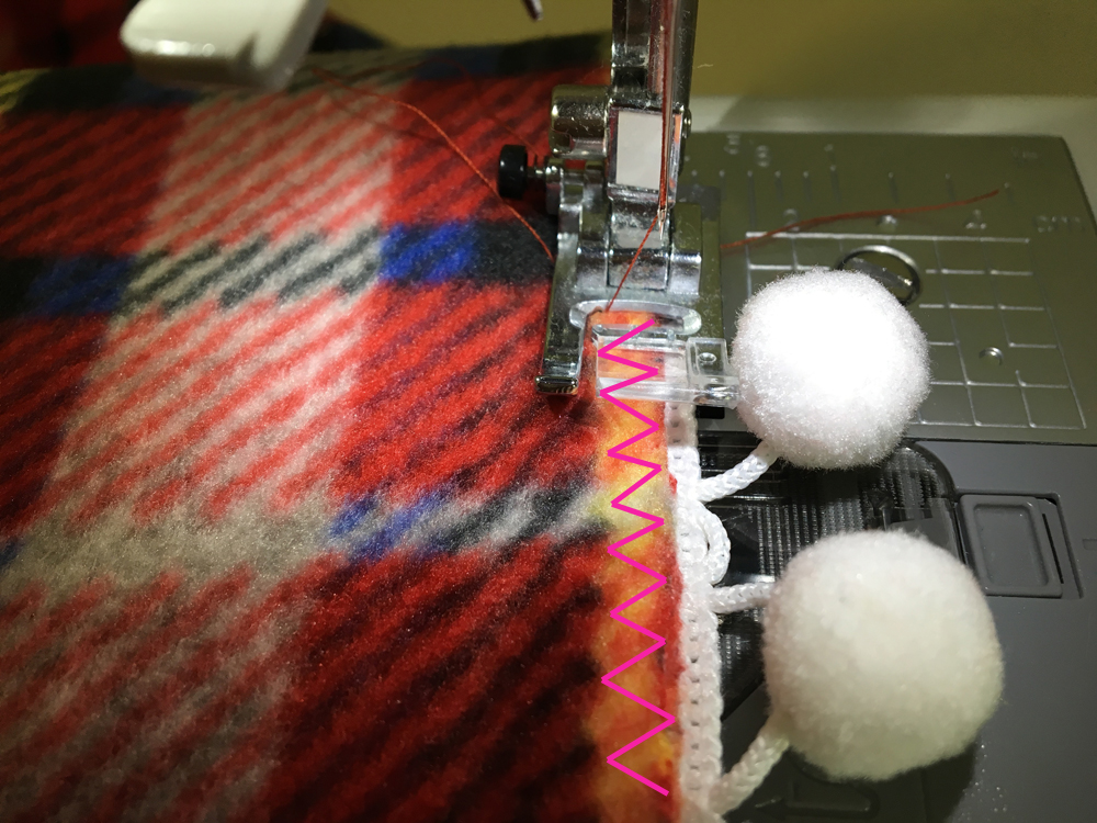 Fleece and pom pom trim on the sewing machine, making a zig zag stitch