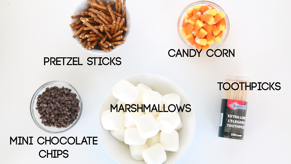 Marshmallow Snowman supplies: pretzel sticks, candy corn, chocolate chips, marshmallows, toothpicks
