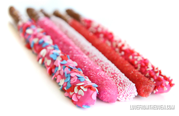 Valentine\'s pretzels rods dipped into colored candy and sprinkles