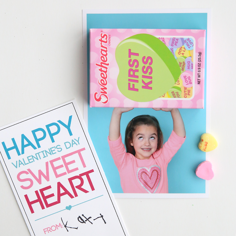 Photo of a little girl with her arms above her head, with a box of sweethearts candy glued onto the photo so it looks like the girl is holding up the box