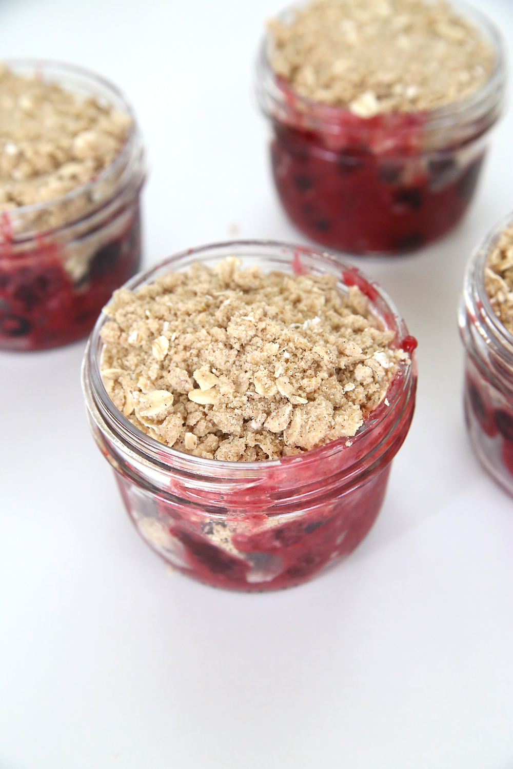 Berries and streusel layered in small mason jars
