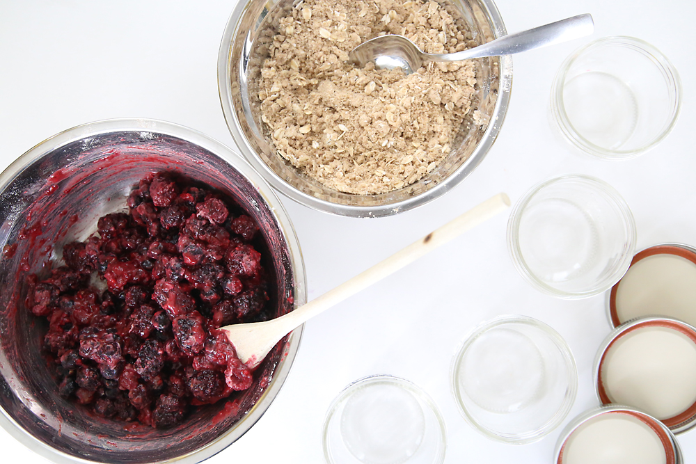 berries and sugar in a bowl; oat struesel topping in a bowl; small mason jars