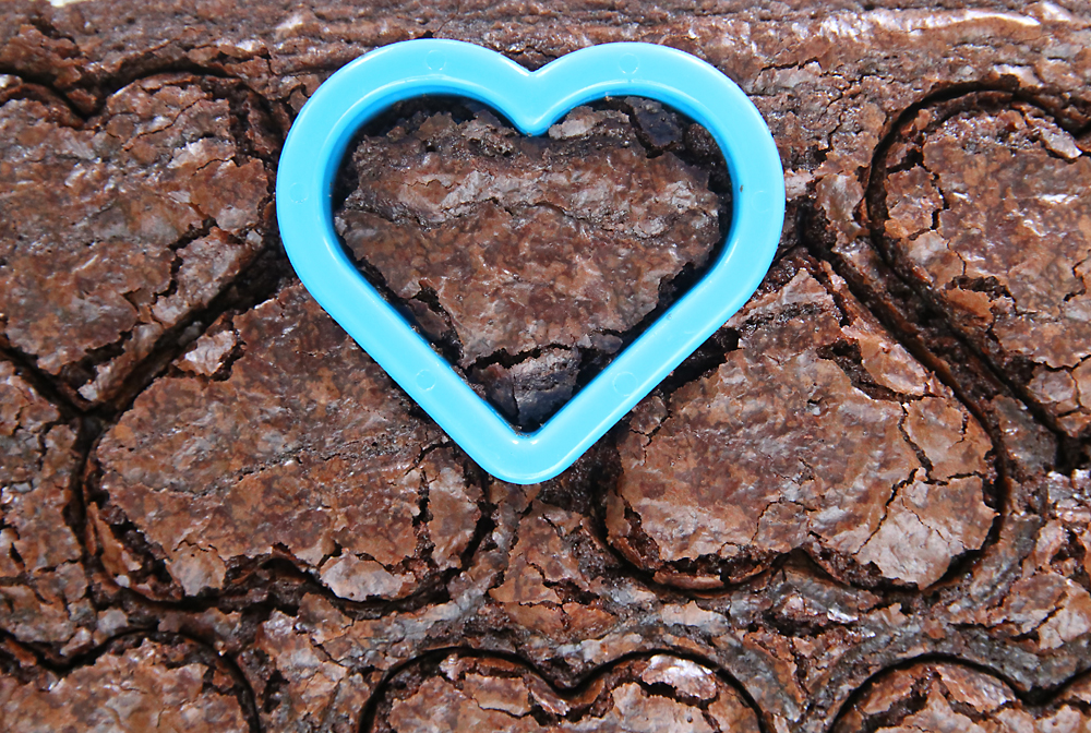 Herat cookie cutter cutting hearts out of sheet of brownies