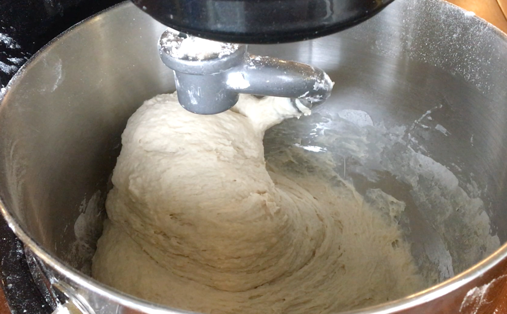 French bread dough in the bowl of a mixer