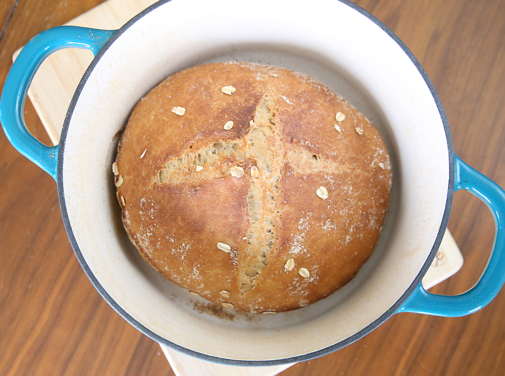 A loaf of whole wheat artisan bread in a dutch oven