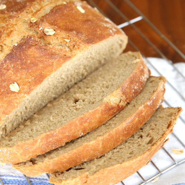 Whole wheat artisan bread sliced on a cooling rack