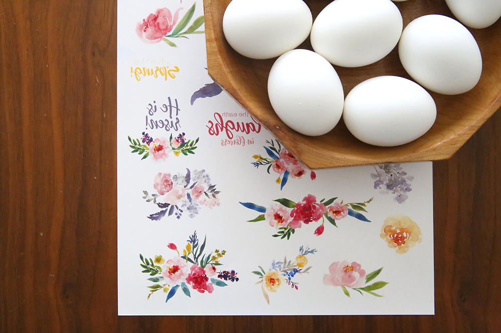 A bowl of eggs and a sheet of temporary tattoo paper with floral designs printed in reverse on it