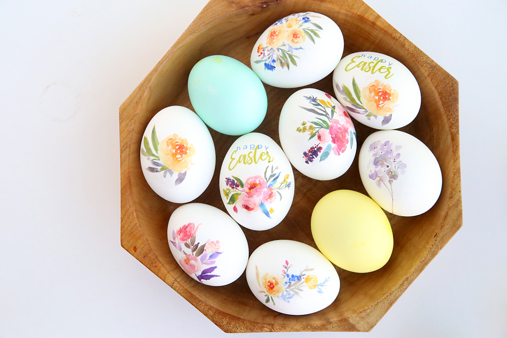 Easter eggs decorated with flowers in a wooden bowl