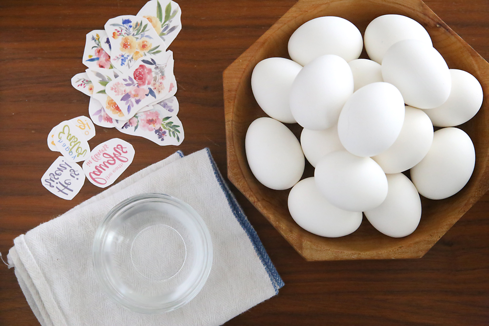 A bowl of hard boiled eggs; flowers printed on tattoo paper, water, towel