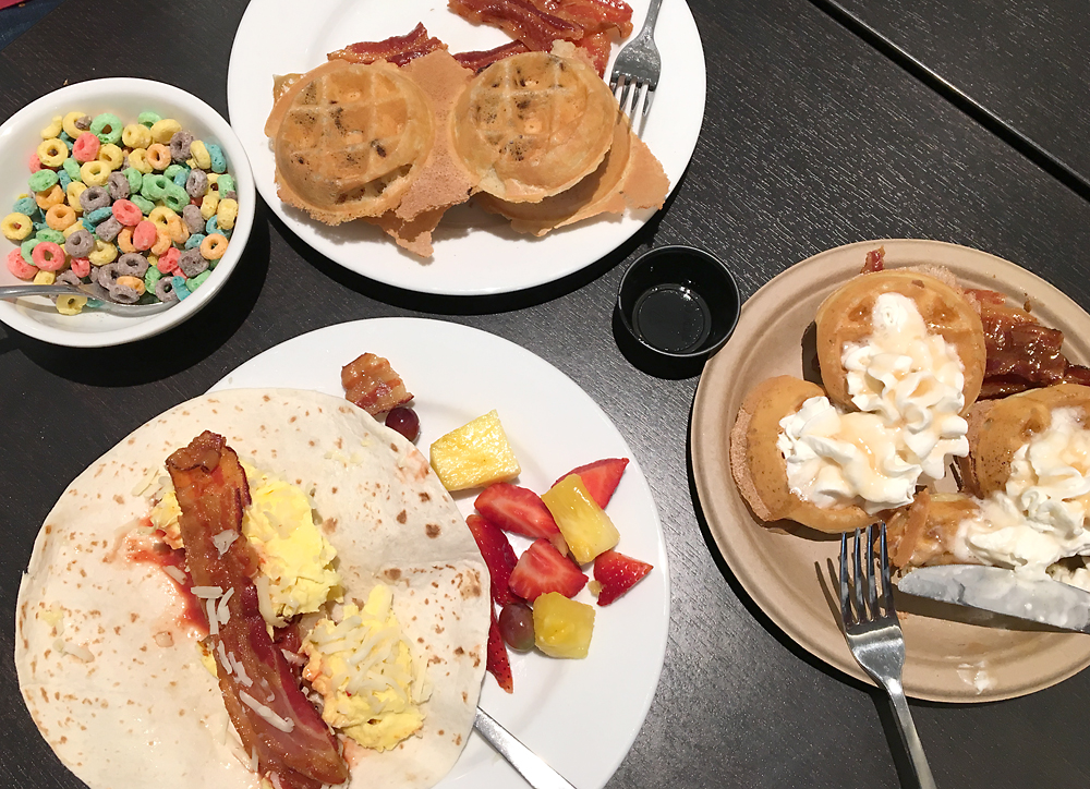 A table with plates full of breakfast food on it