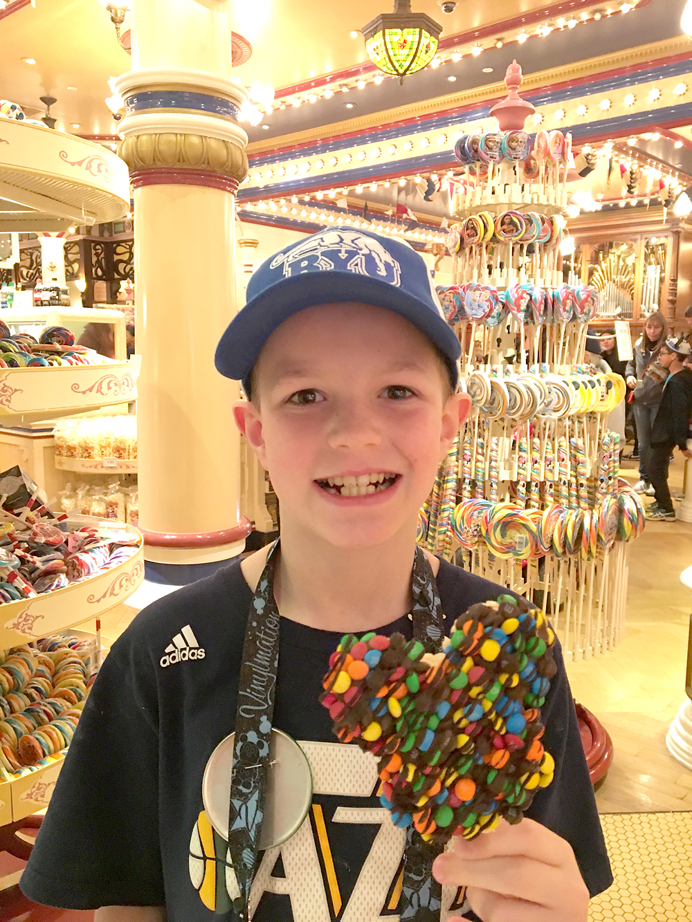 A boy holding a Mickey Mouse rice krispie treat at Disneyland