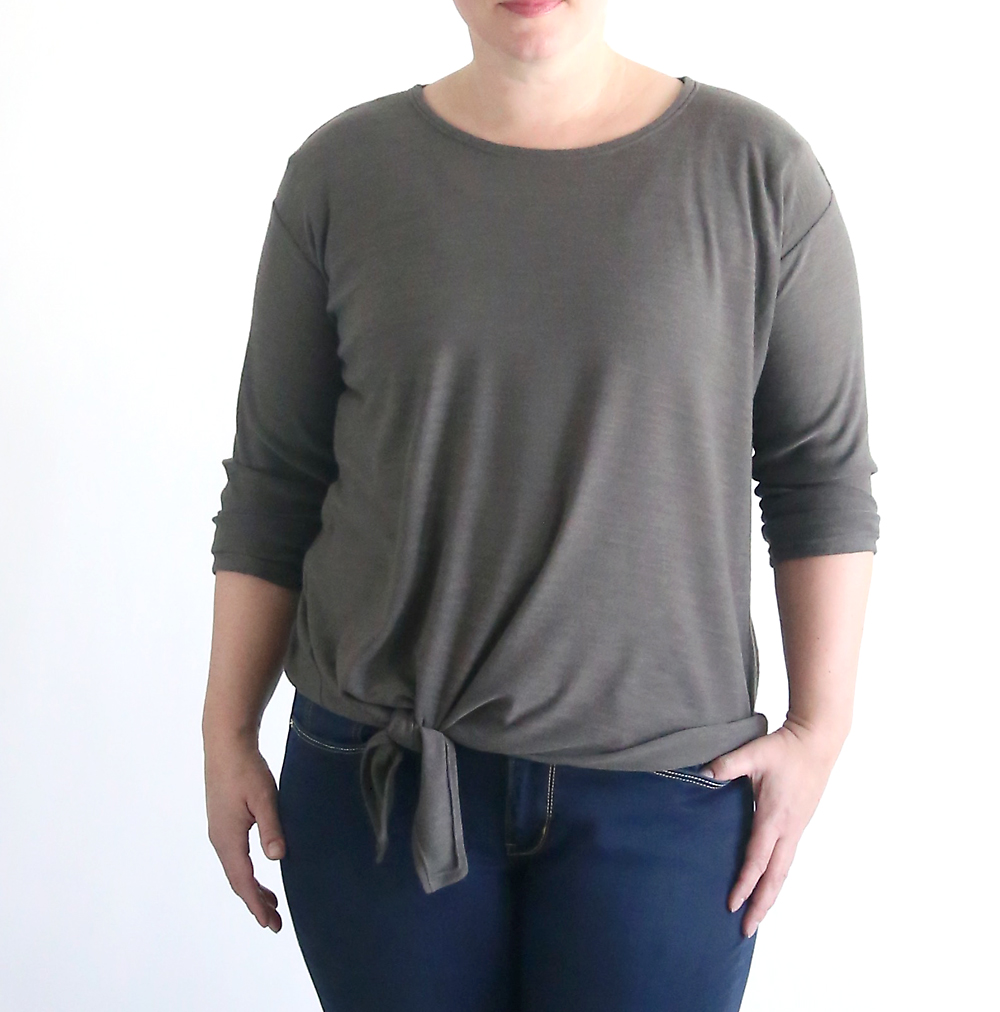 A woman wearing a sweater with a tie front hem made from a free pdf sewing pattern