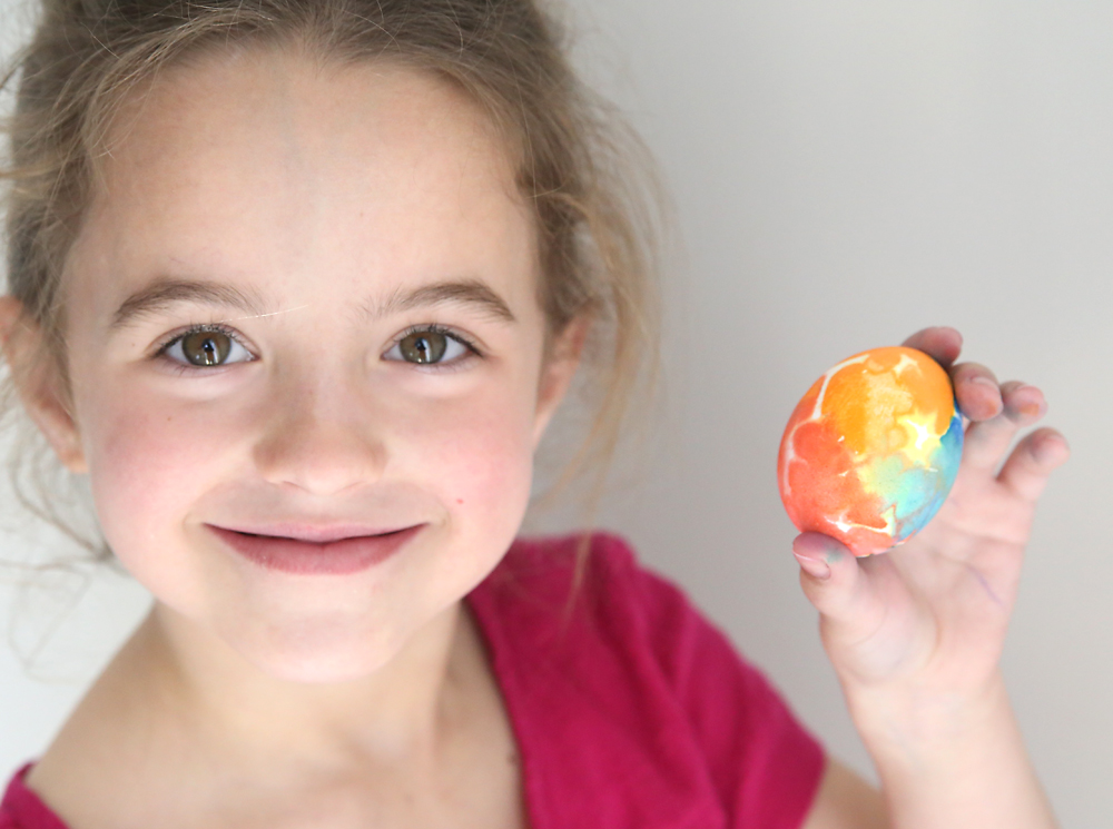 Little girl holding a colorful Easter egg