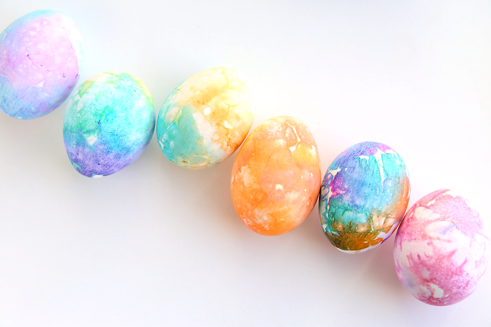 A row of Easter eggs dyed pretty colors using tissue paper