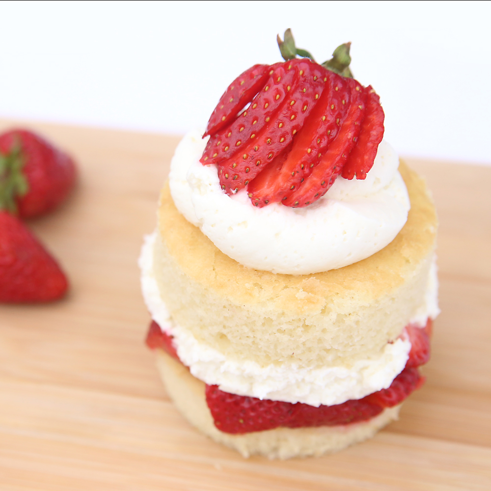A piece of strawberry shortcake with sliced berry on top