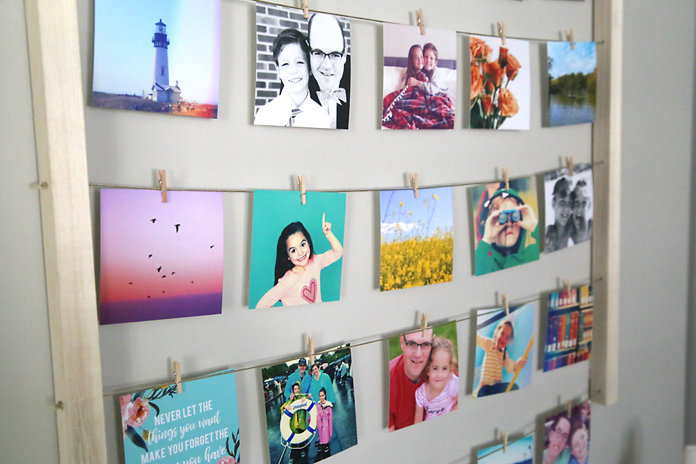 Photos hanging on lines of twine with mini clothespins