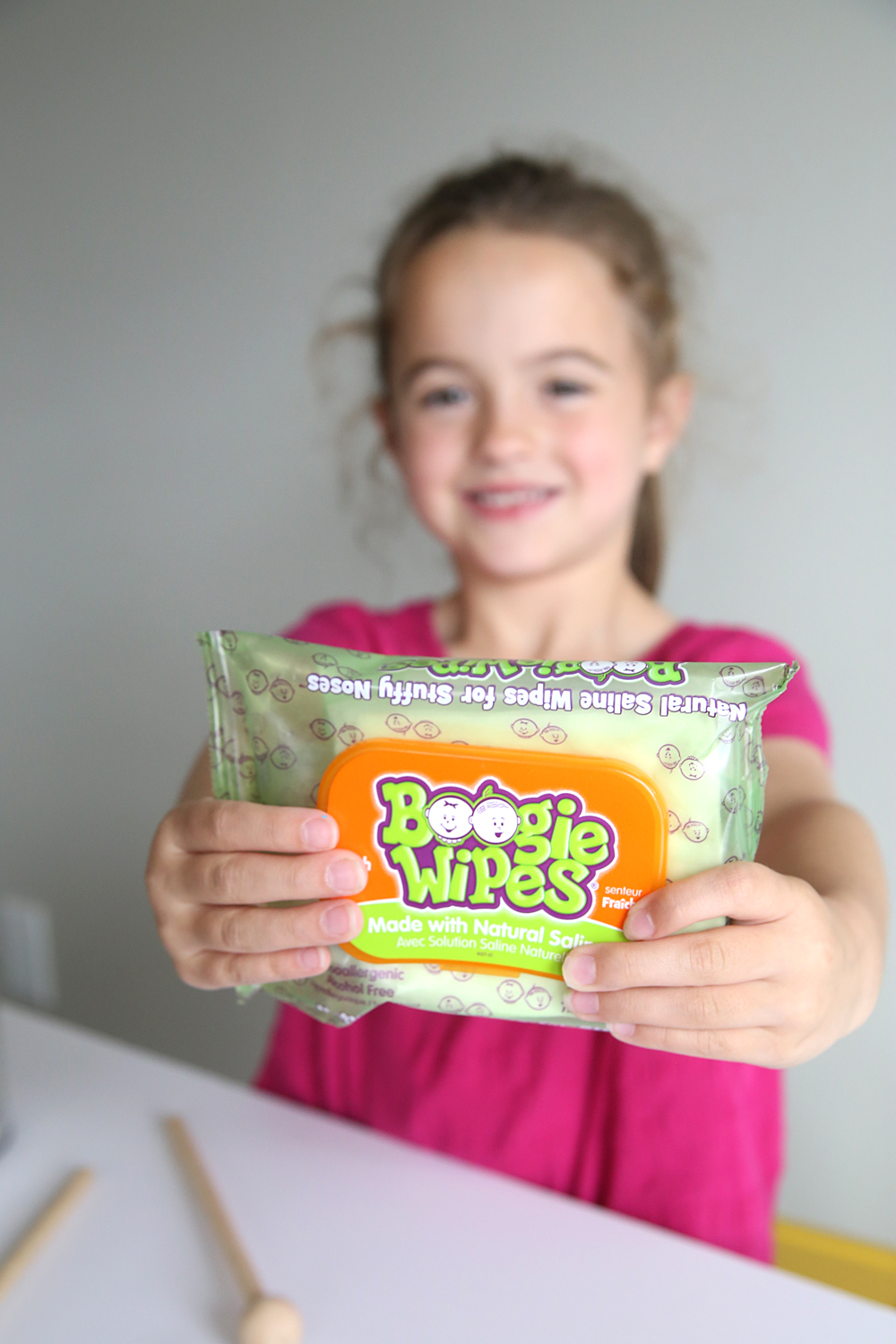 A girl holding package of boogie wipes