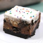 A piece of brownie ice cream cake with sprinkles on top