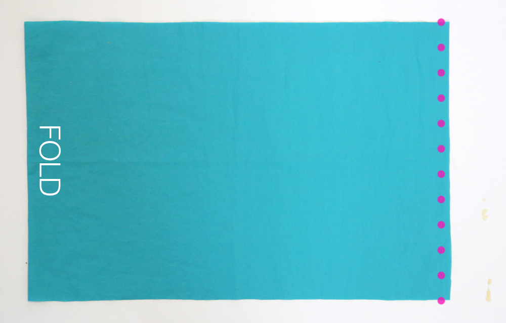 Wide piece of blue fabric folded in half with side seam marked