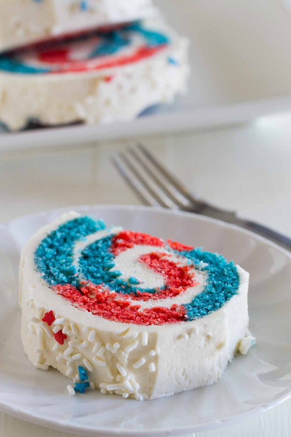 A blue and red cake roll with white frosting